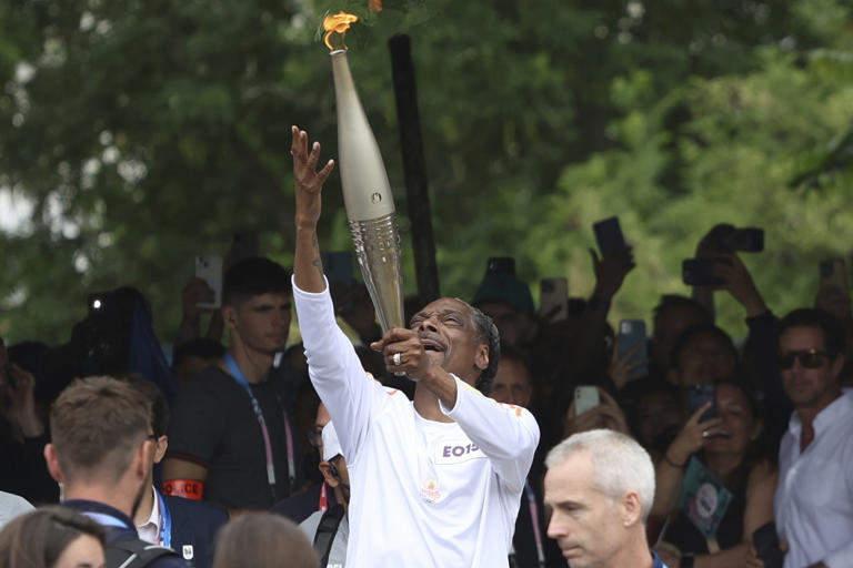 Snoop Dogg Carries Olympic Torch Through Paris Suburbs Ahead of Opening Ceremony